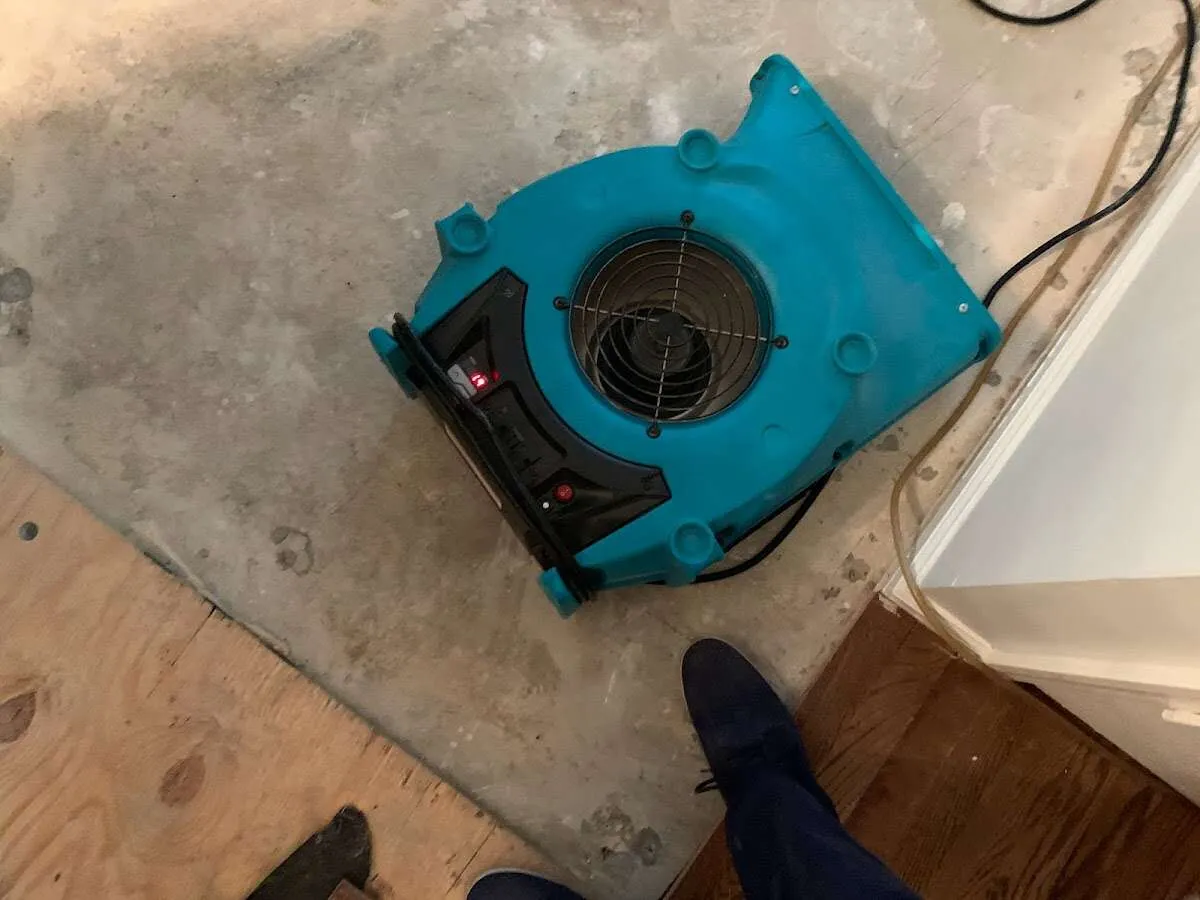 Air mover drying subfloor during Leak Detection & Repair in Seaside